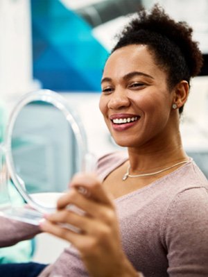 Woman smiling while looking at reflection in mirror
