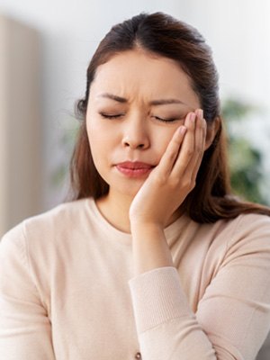 Woman with toothache sitting on couch