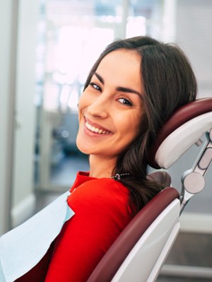 Woman smiling while sitting in treatment chair