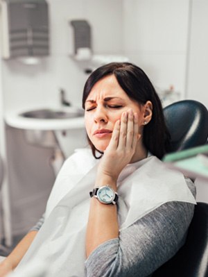 Patient with toothache sitting in treatment chair