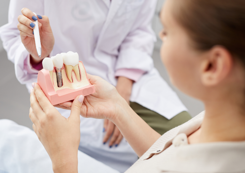 Dentist showing patient dental implant mold