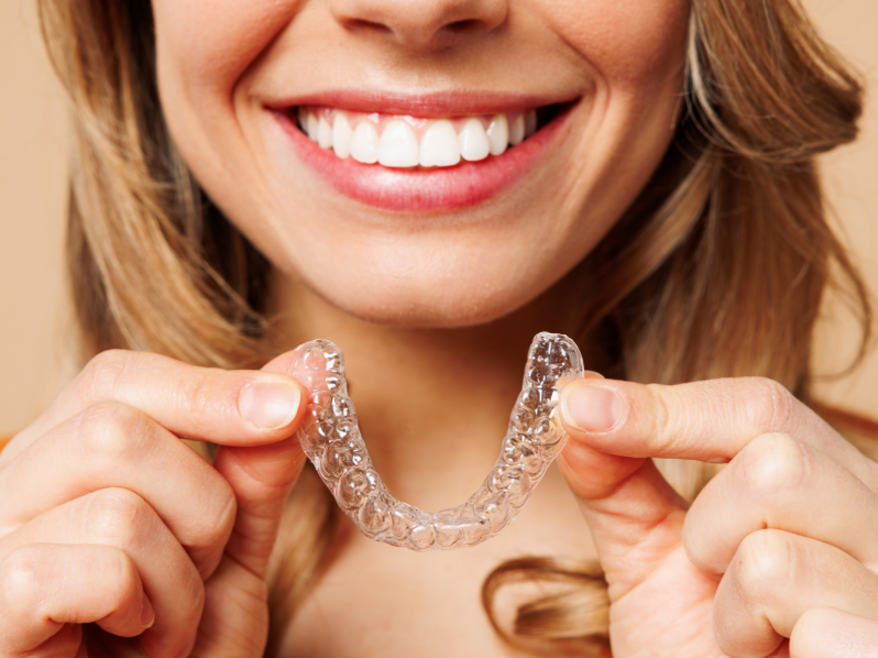 Woman holding clear aligner